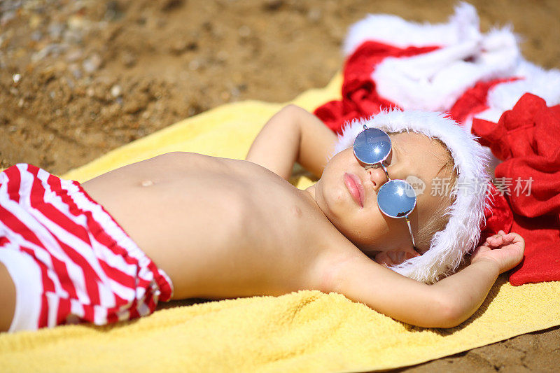 小圣诞老人在海滩上晒太阳