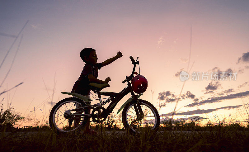 男孩在日落时骑自行车