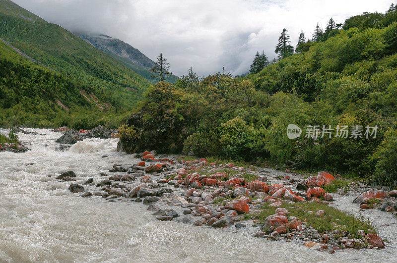 红色的石头在快速流动的河流哲多，中国四川