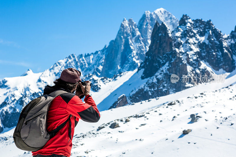 男摄影师用单反相机拍摄山脉