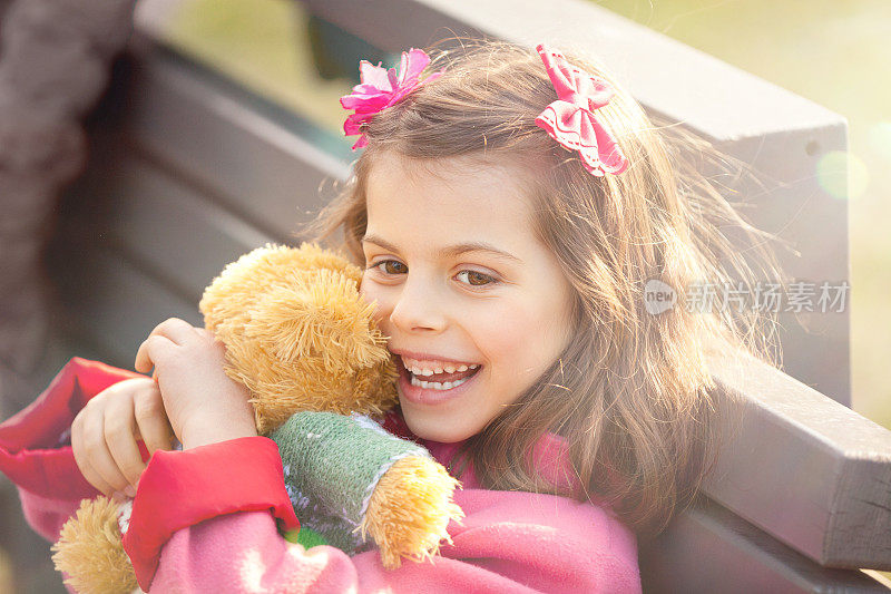 小女孩在户外玩她的泰迪熊
