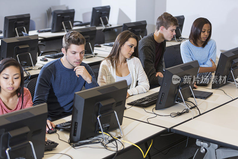 5个学生在教室里使用台式电脑