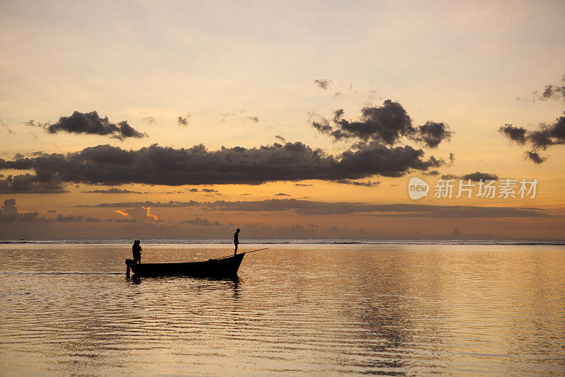 渔船在夕阳下漂浮在水面上