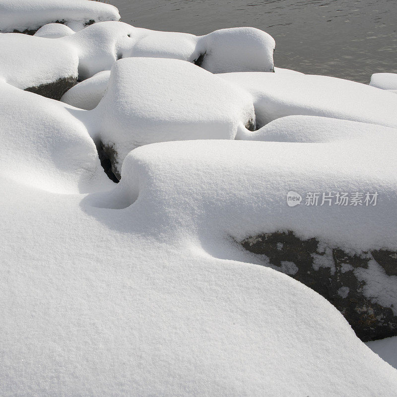 奥内达加湖岸边被雪覆盖的岩石