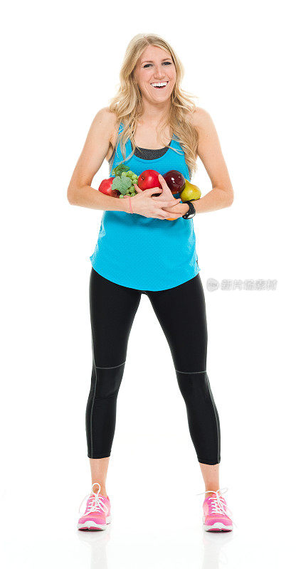 微笑的女运动员拿着水果