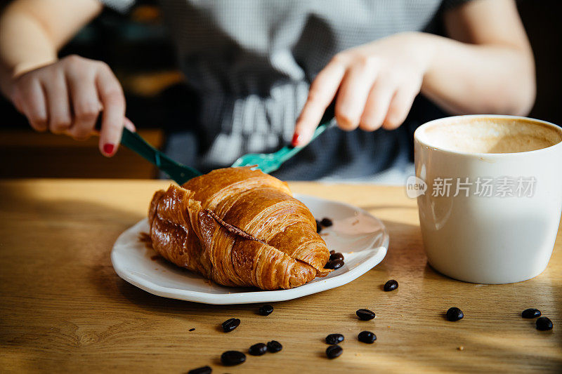 亚洲女孩吃欧式早餐，咖啡和羊角面包，上海，中国