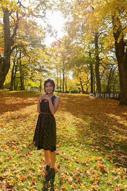 年轻美丽的亚洲女人享受秋天的季节