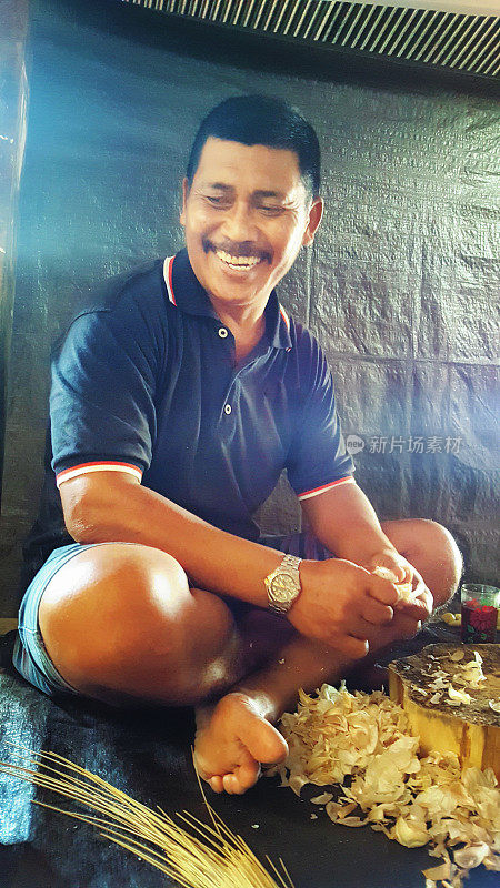 成熟的印度尼西亚男子正在为村宴准备大蒜