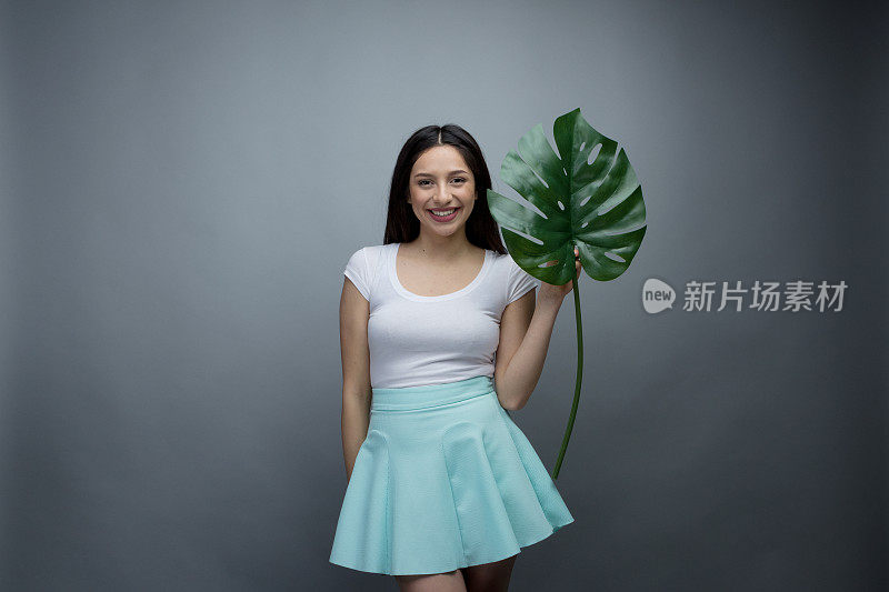 美丽的年轻女子拿着一片叶子