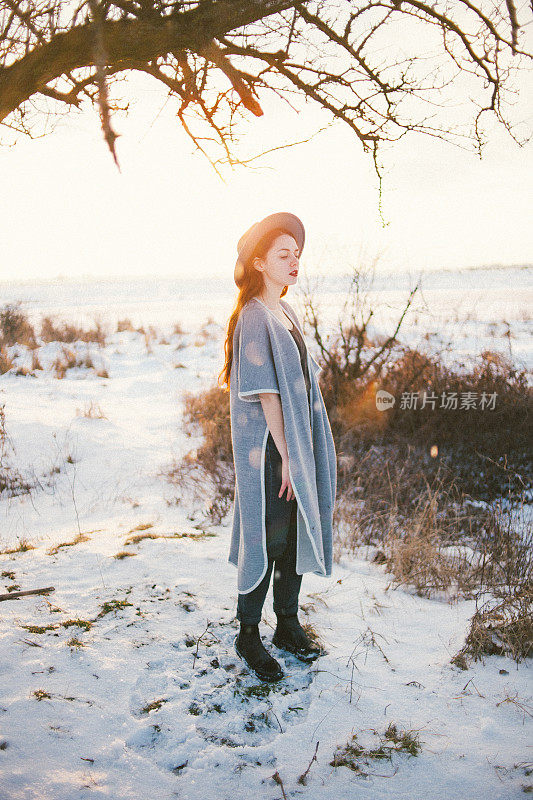 快乐的女人在田野里享受飘落的雪