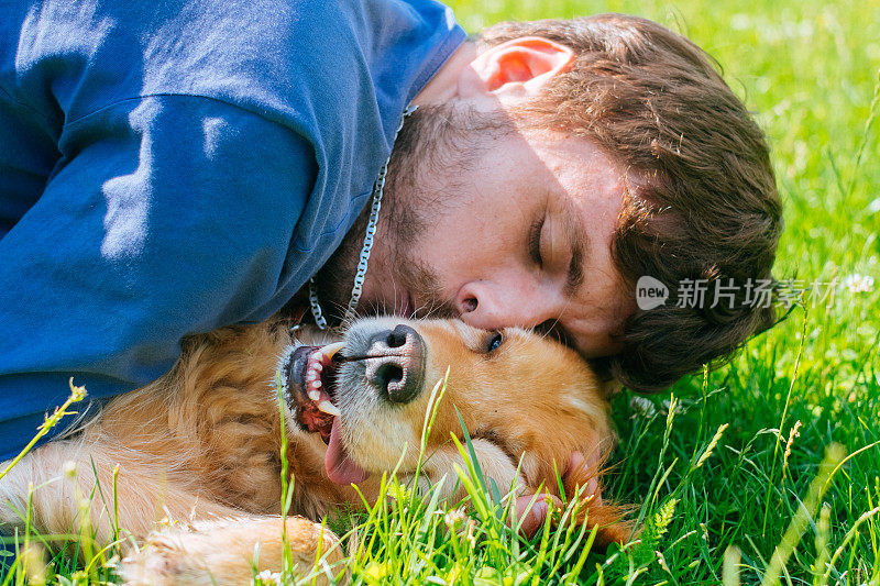 一个快乐的男人和一只拉布拉多犬在秋天的城市公园