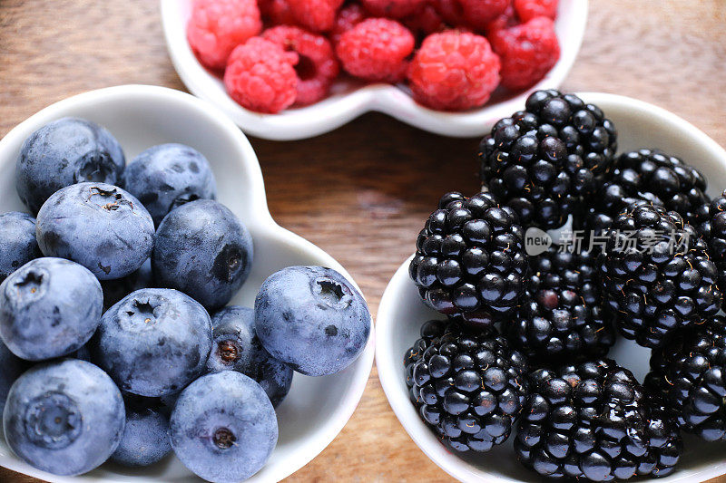 浆果:蓝莓，覆盆子，白木背景