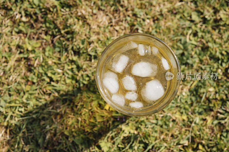 在一个炎热的夏天，在花园的草坪上喝一杯冰茶。