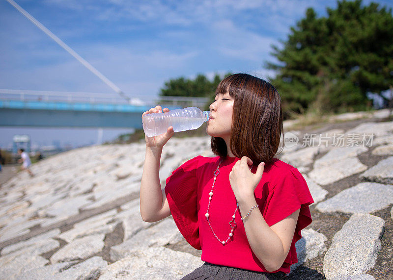 年轻女子在河边喝水