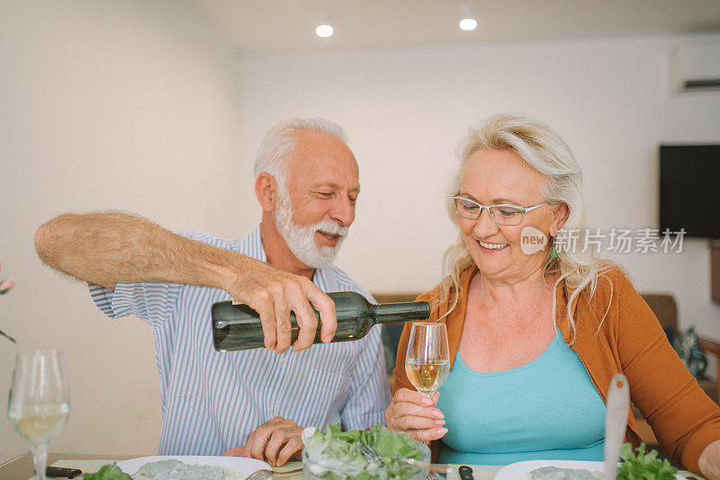 老人在给妻子斟酒