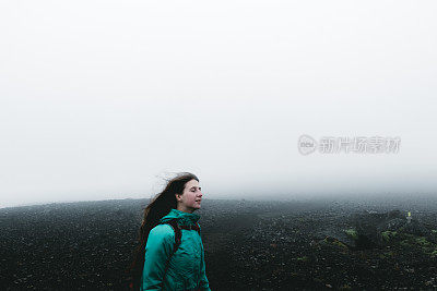 女人背包徒步旅行，虽然火山景观和风在冰岛无处