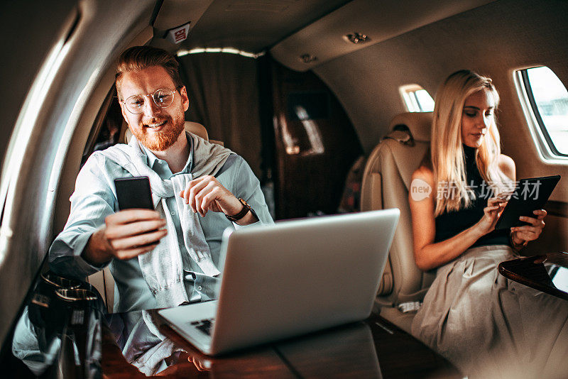 年轻的成功夫妇在乘坐私人飞机旅行的同时工作