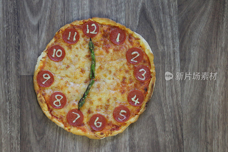 这是一个自制披萨时钟的图片，上面有意大利辣香肠片、马苏里拉奶酪和芦笋作为时钟指针，告诉你时间是19:00到7:00，这是意大利披萨餐厅为孩子们的生日聚会食物准备的儿童披萨时钟