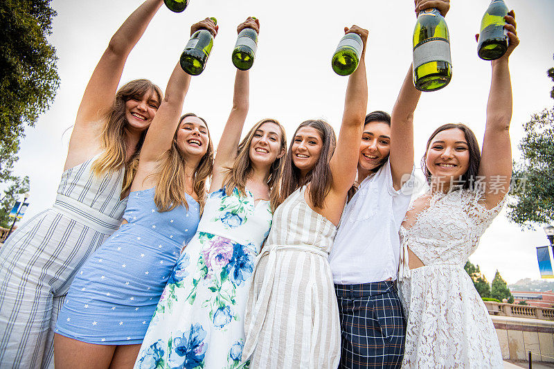 六名女大学生高举香槟酒瓶庆祝毕业