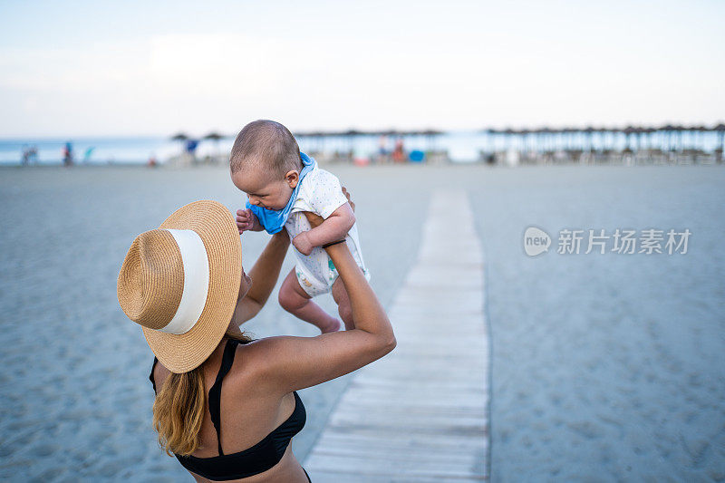 一个在海滩上抱着婴儿的陌生女人