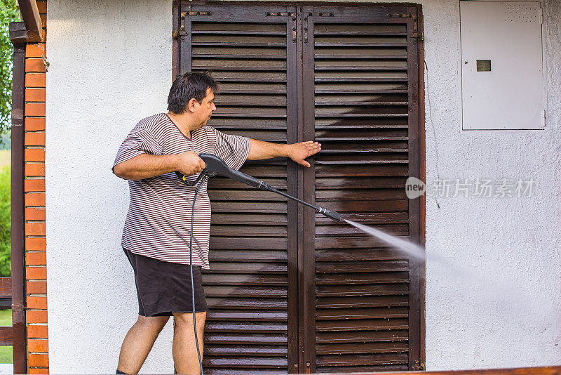 男人用喷水器清洁房屋