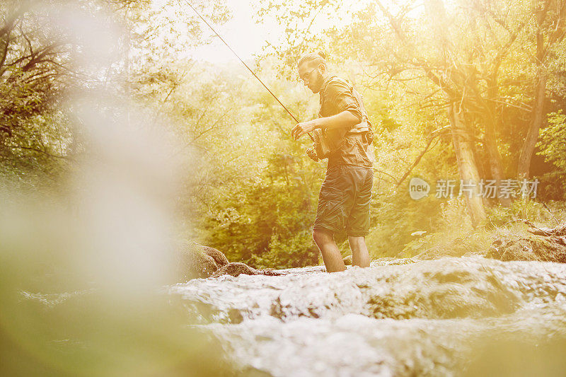 一个年轻人在河边钓鱼