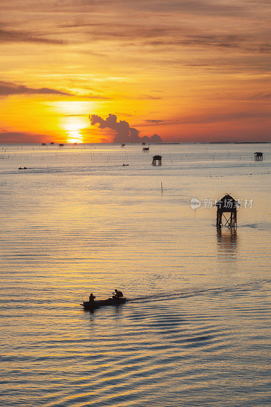 日落的渔民船和鱼笼子在海水中，泰国