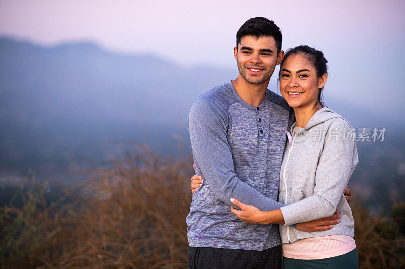 年轻的西班牙裔夫妇在看美丽的山景