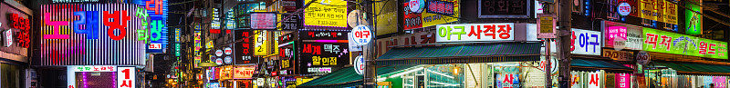 五颜六色的霓虹灯照亮了韩国首尔的购物街全景