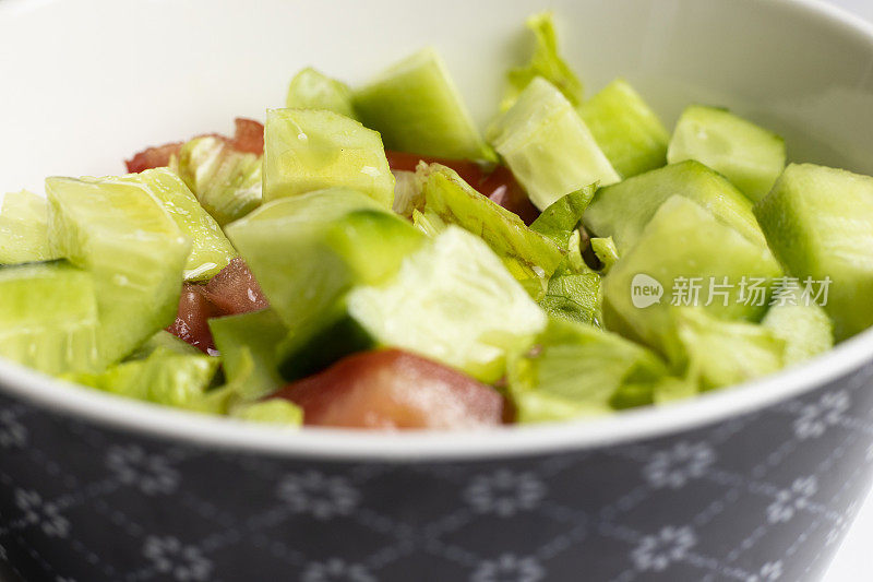 盘子上的沙拉特写。黄瓜，番茄和莴苣。