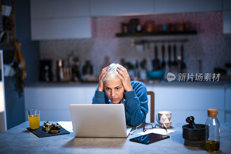 深夜在家工作时应对压力和疲惫的老年妇女