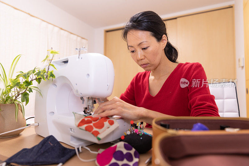 一名日本妇女在家里制作面具