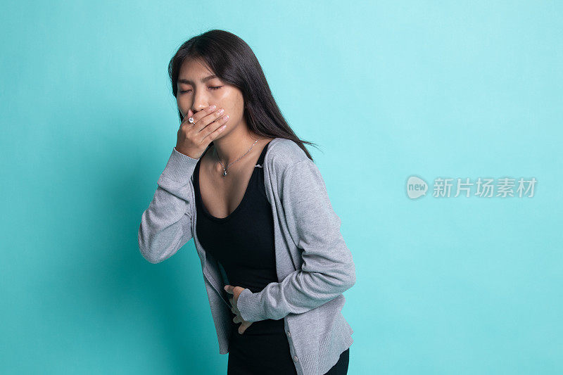 一个年轻的亚洲女人胃疼得快要吐了。
