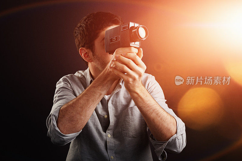 年轻的电影摄影师用老式的带有闪光镜头的摄影机拍摄
