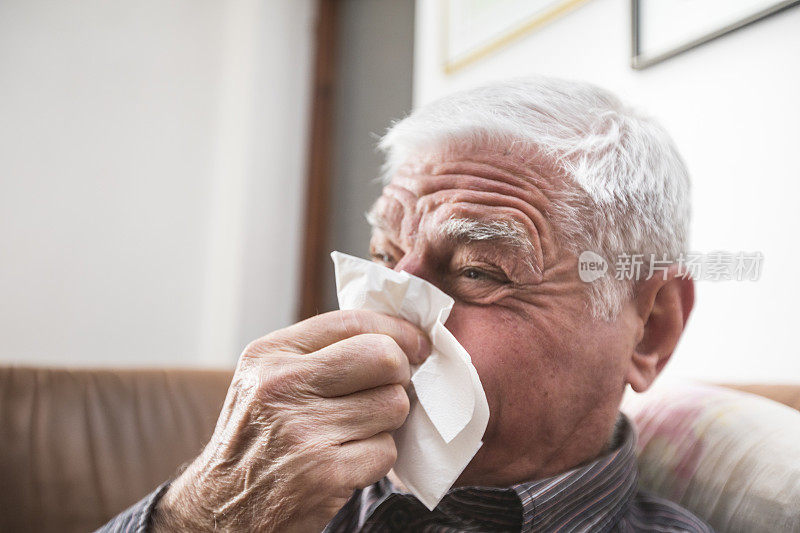 老年男子感冒病毒和擤鼻涕