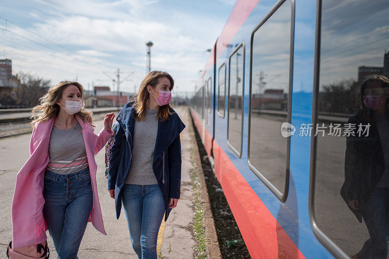 两个戴着防护面罩的妇女经过火车
