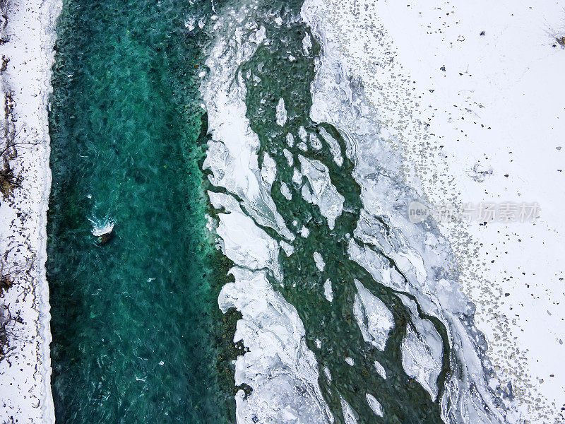 航拍蓝色和绿色的河流与雪和碎冰在冬季冰漂移在俄罗斯阿尔泰山脉。