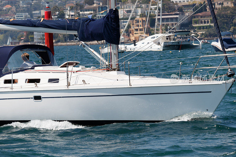 帆船行驶在悉尼港在一个阳光明媚的日子，与双湾和点笛手的背景