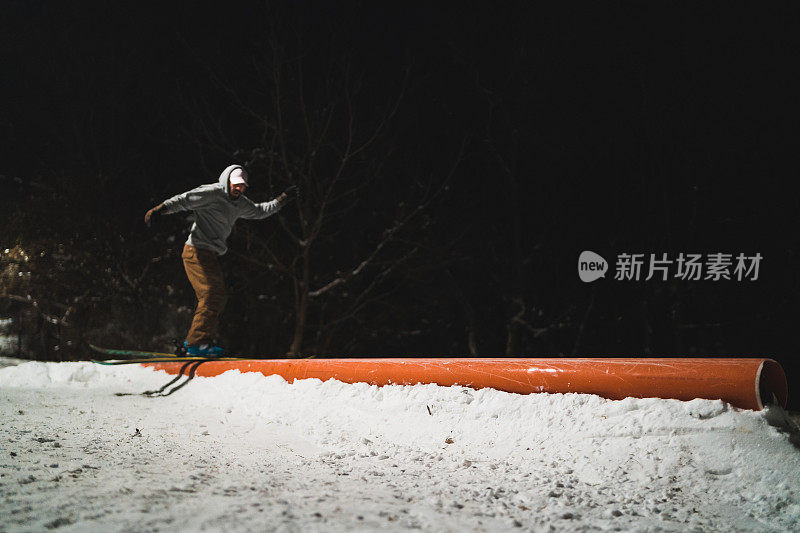 自由式滑雪者在城市公园的铁轨上表演特技