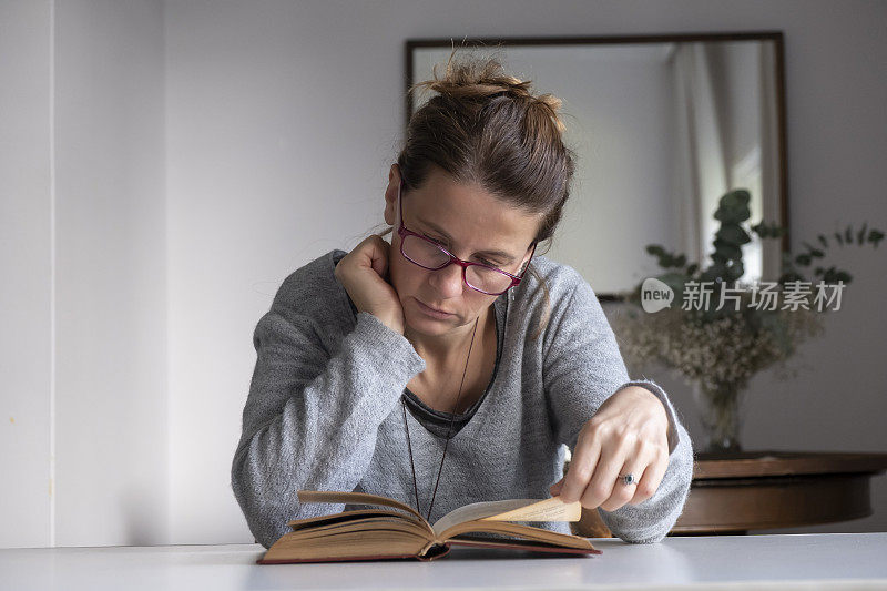 戴眼镜的女人在窗前看书