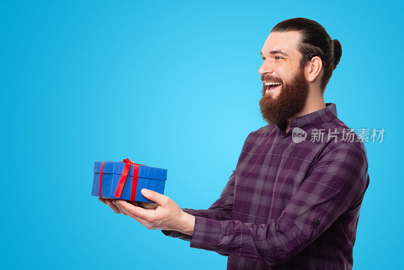 一个留着胡子的年轻人把礼盒送给了别人