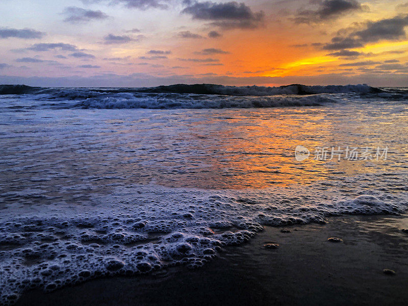 加州日落在海滩从一个低角度捕捉海洋泡沫波