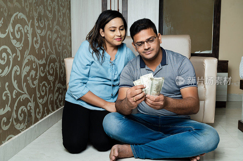 印度夫妇持有钞票或数钱。