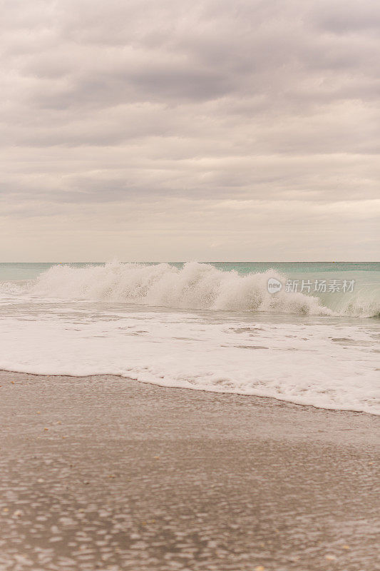 在2021年1月的中午，蓝绿色的海浪横扫佛罗里达州的朱诺海滩