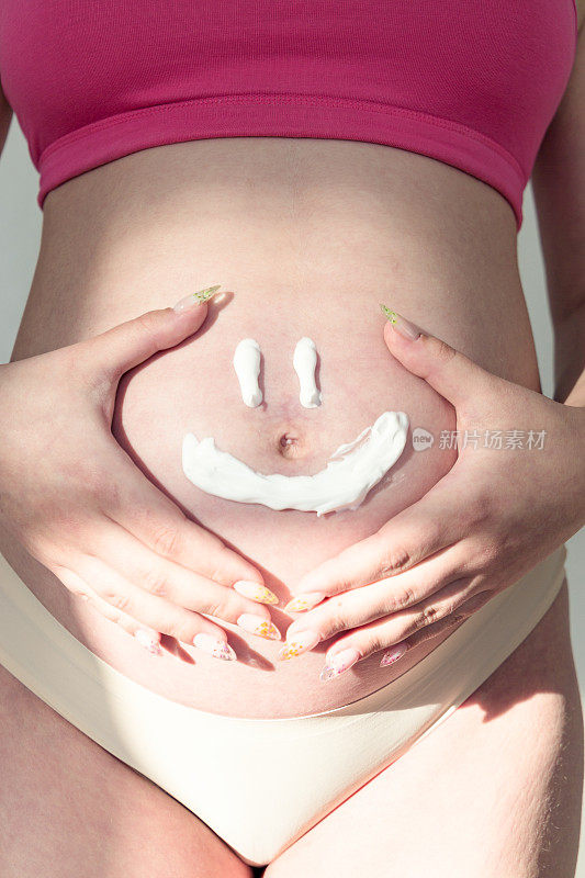 范妮的脸贴在孕妇的肚子上。幸福家庭的概念