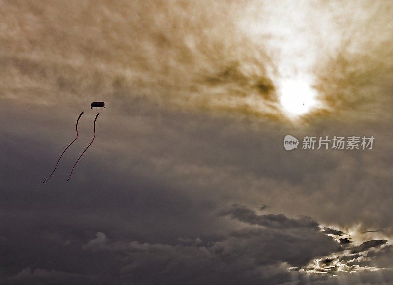 一个长尾表演风筝在暴风雨的天空中飞翔