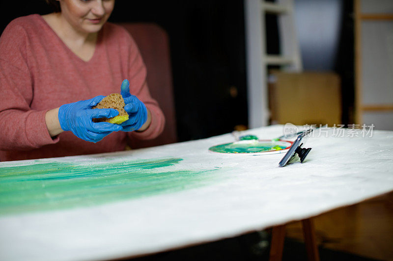 一名女子用手机做视频博客，解释用海绵画画的方法