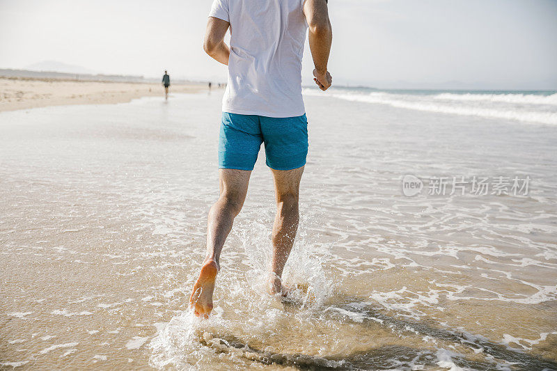 在海滩上奔跑的陌生年轻人