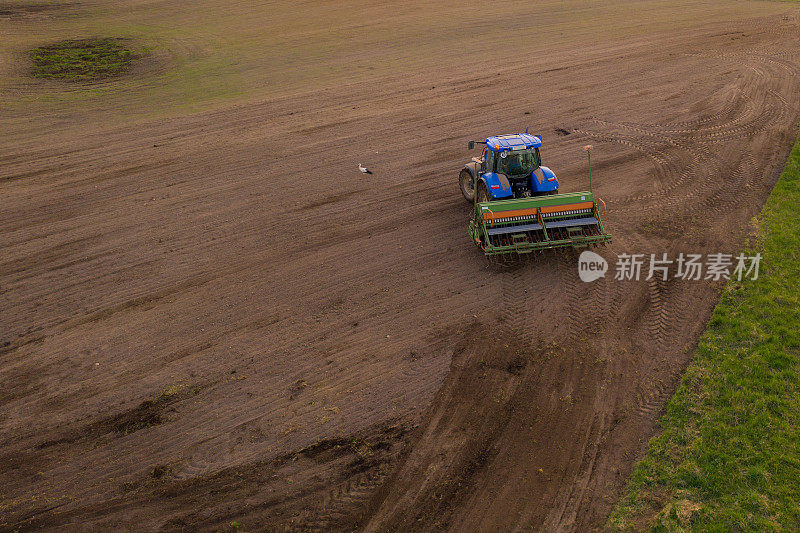 农用拖拉机在田里工作的无人机视图在夏天的白天