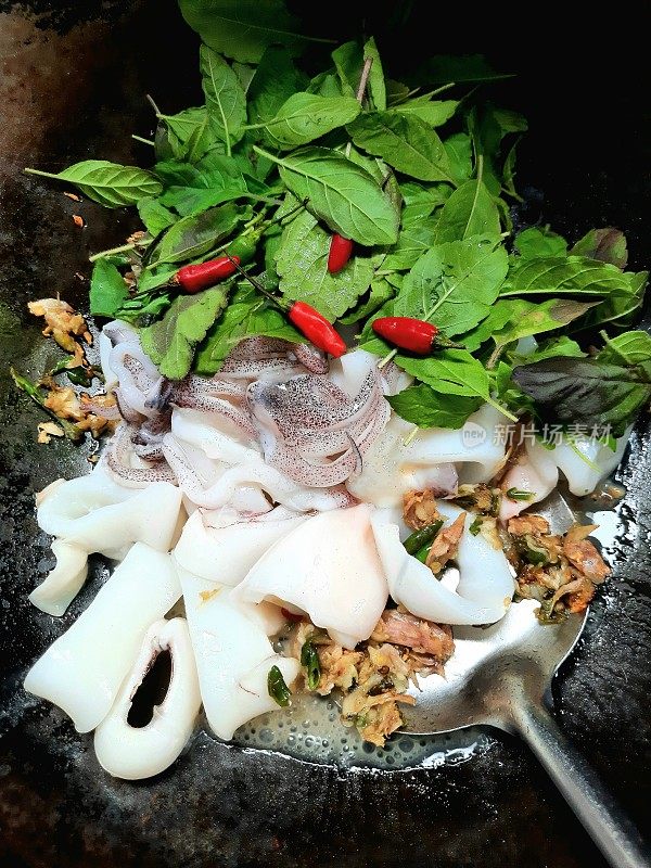 煮辣鱿鱼罗勒在煮锅-泰国菜的准备。